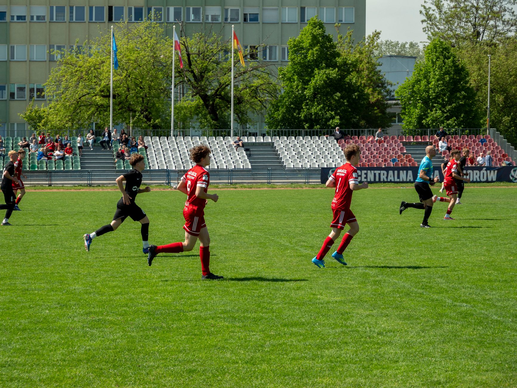 Players competing in a youth soccer match at a stadium in Wrocław, Poland.