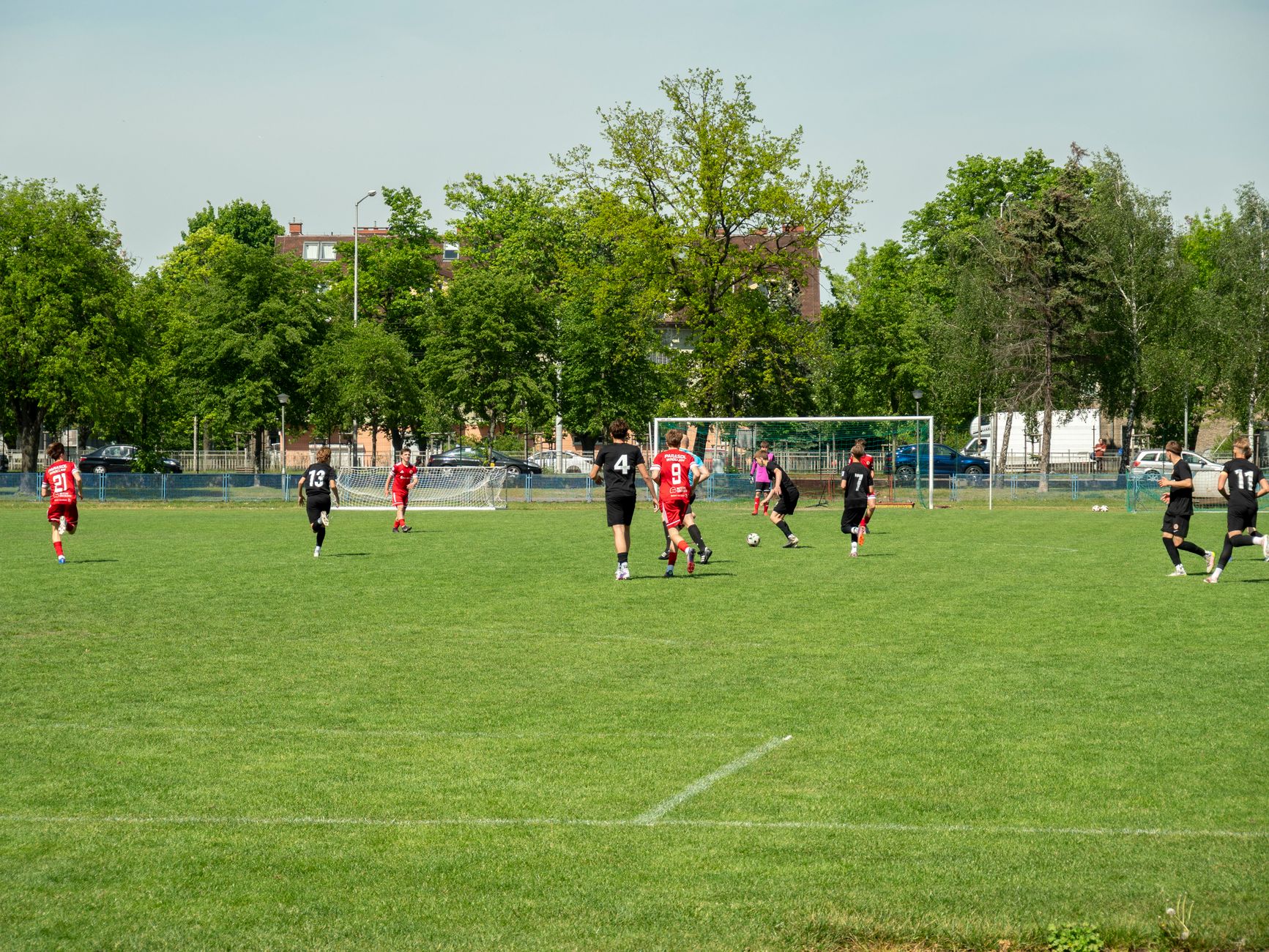 Amateur soccer players compete in a local match at a grassy field in Wrocław, Poland.