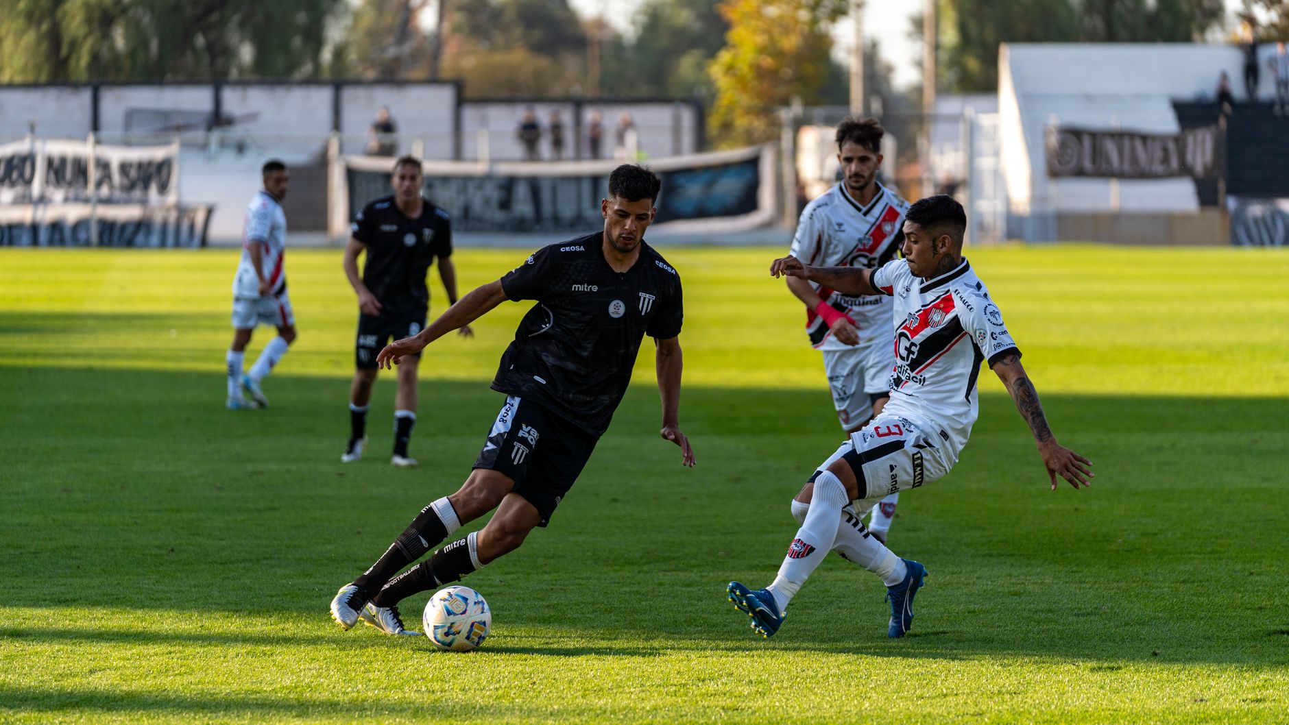 Dynamic shot of a soccer match showing players competing fiercely on a sunny day.