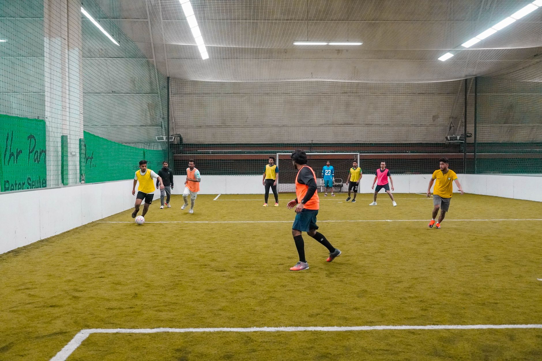 A lively indoor soccer game with diverse players actively engaging in the sport.