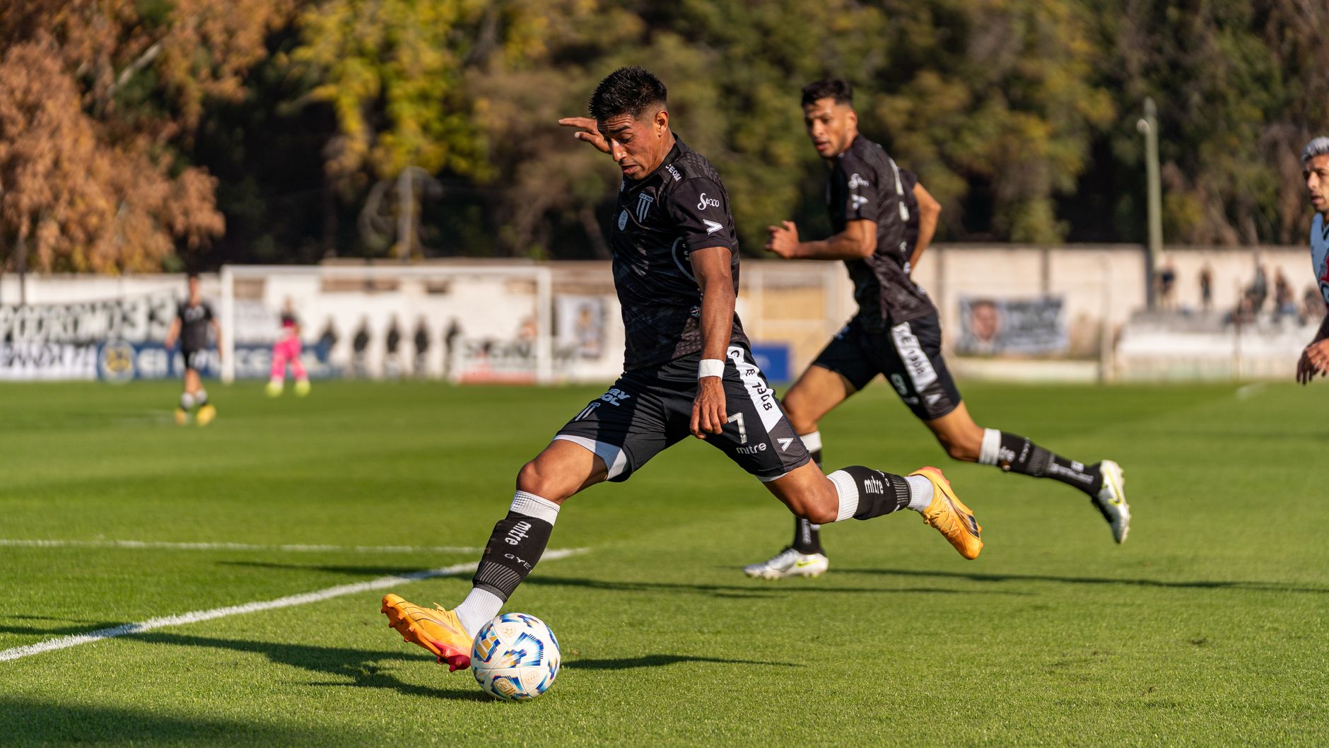 Dynamic action shot of footballers on the field during an outdoor game, showcasing sportsmanship and movement.