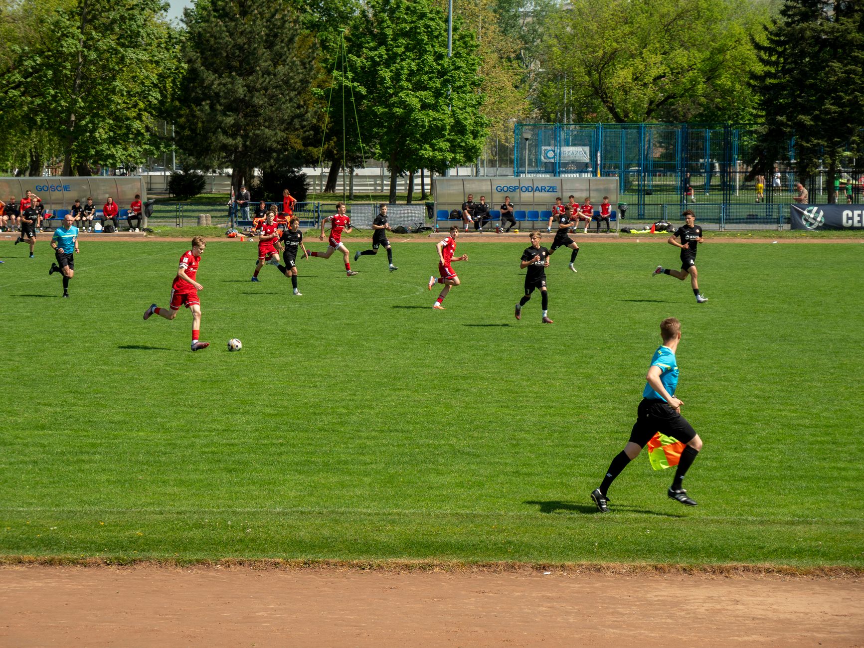 Exciting youth soccer match on a sunny day in Wrocław, Poland, showcasing teamwork and athleticism.