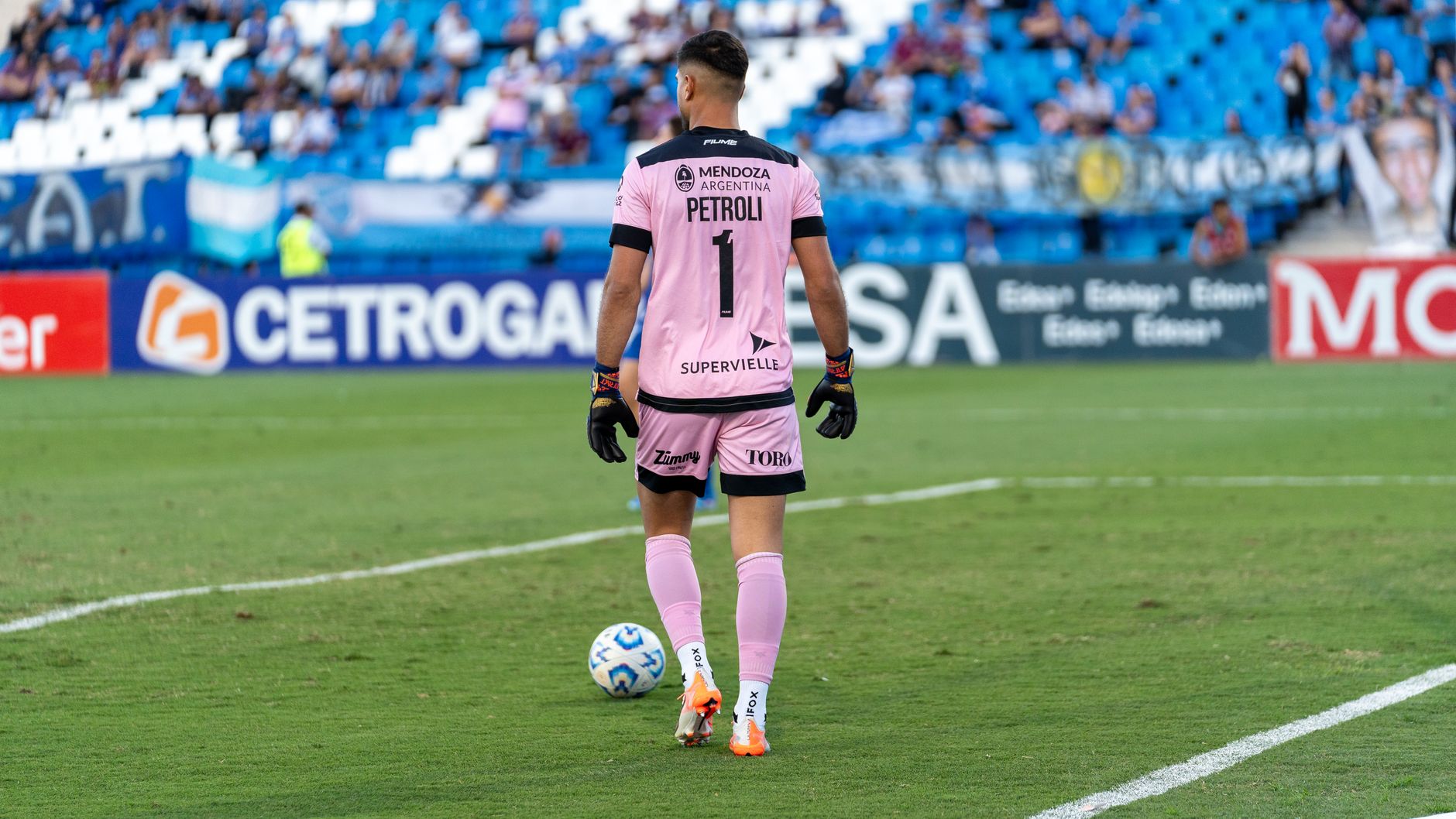 Goalkeeper in action during a football game on a sunny day outdoors.