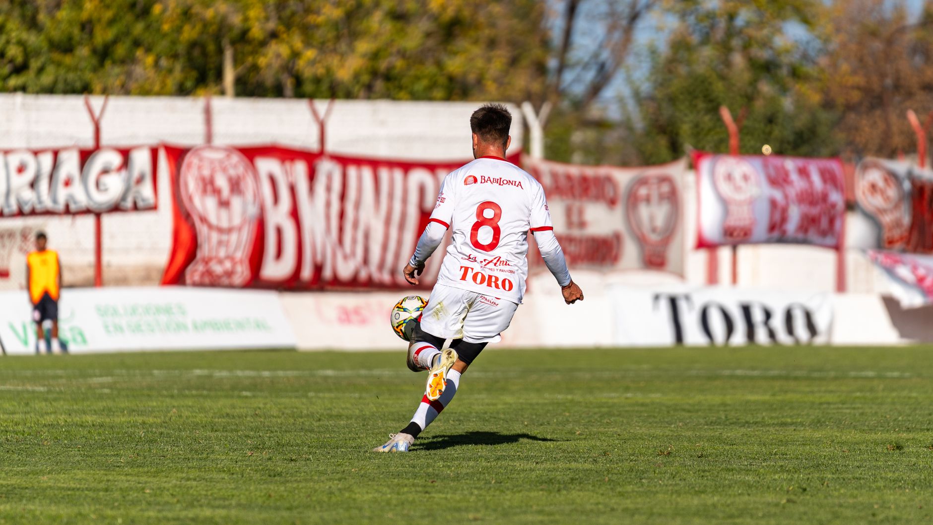 Dynamic shot of a soccer player kicking the ball during an outdoor match.