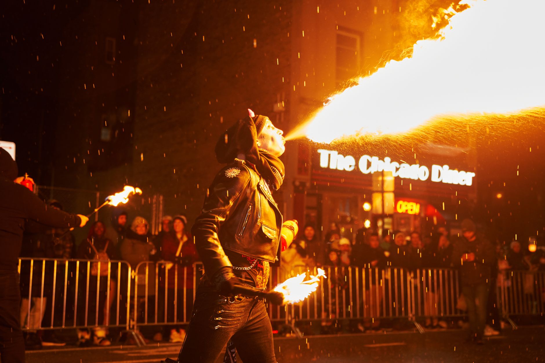 Dynamic fire-breathing performance captured outside The Chicago Diner at night.