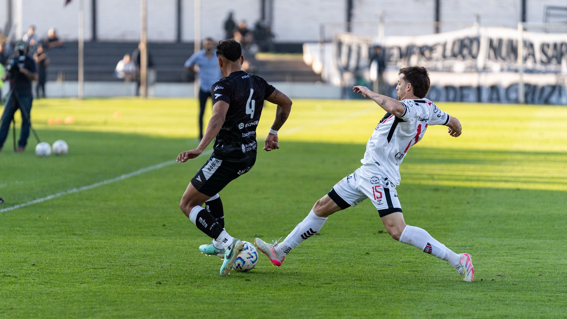 Two soccer players in action during an outdoor match, showcasing agility and competition.