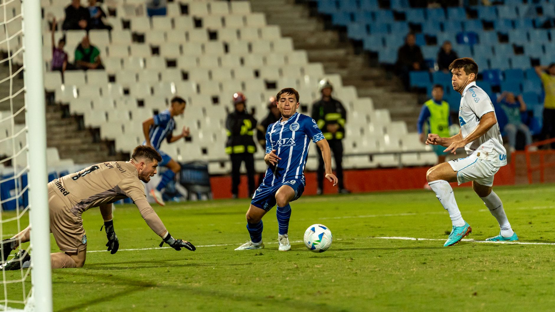 Dynamic shot of soccer players in action during a competitive match on a well-lit field.