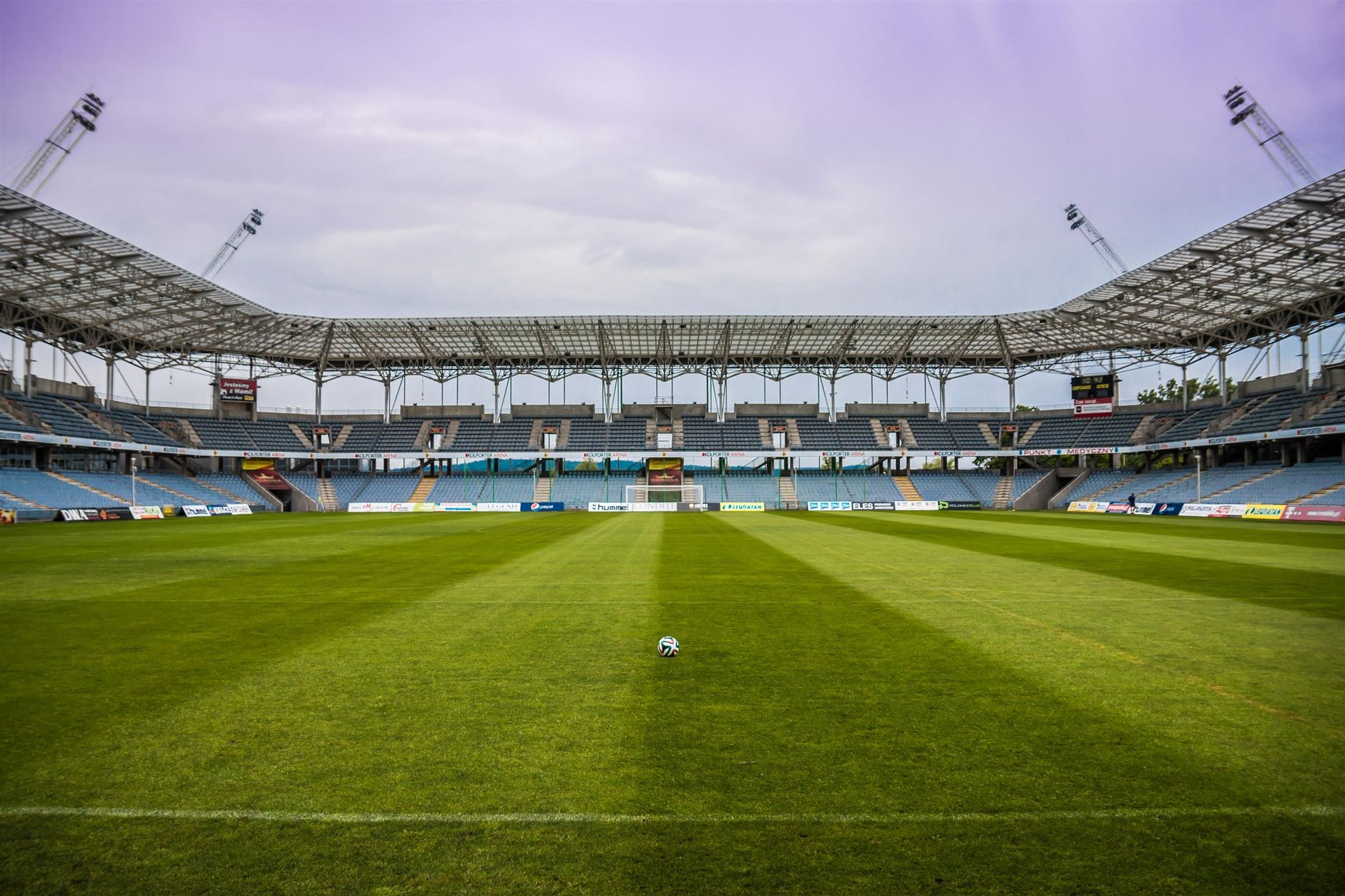 Explore a soccer stadium with clear skies and pristine grass, perfect for any sports event.