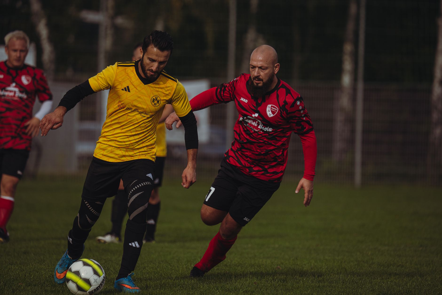 Players in action during a competitive soccer match wearing distinct team jerseys.