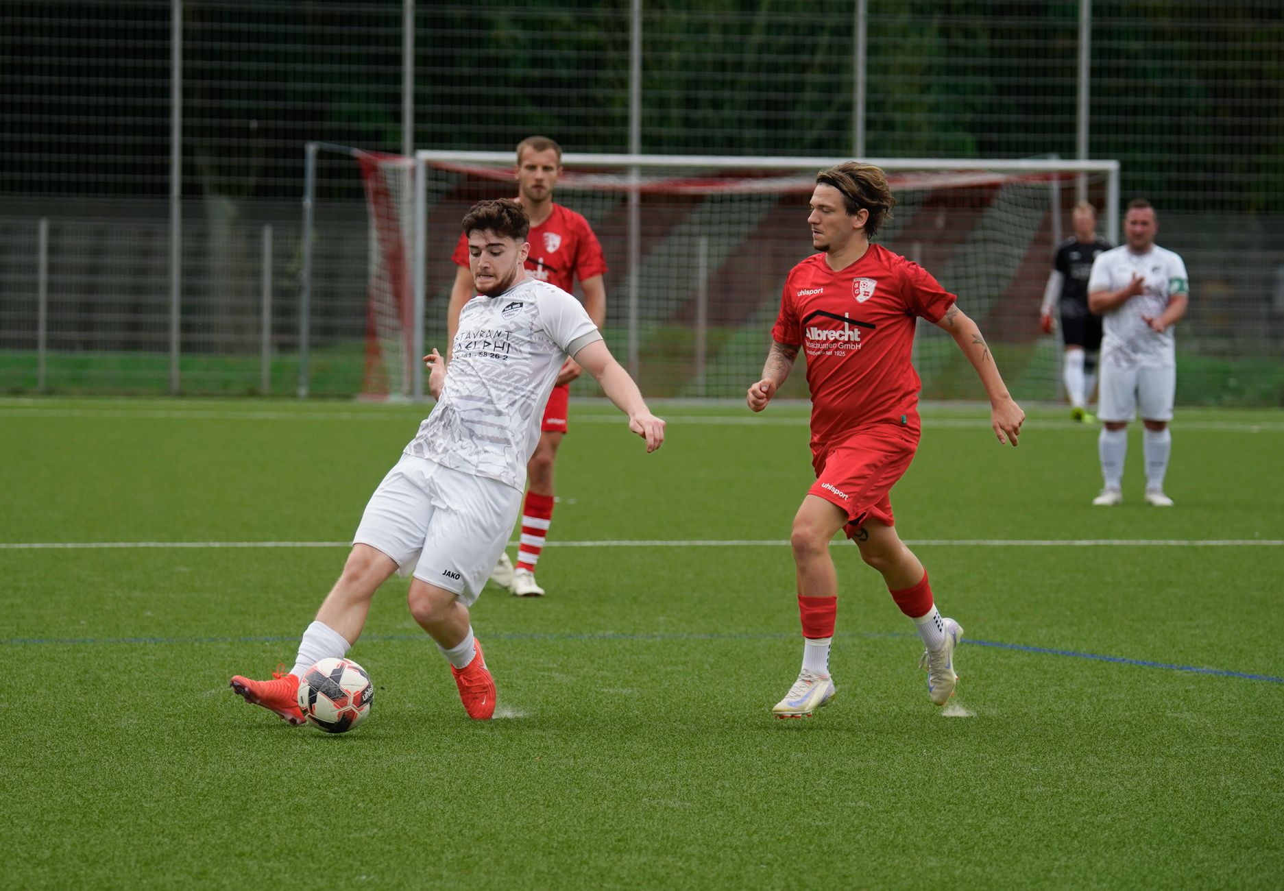 Football players in action during a match on a grassy sports field.