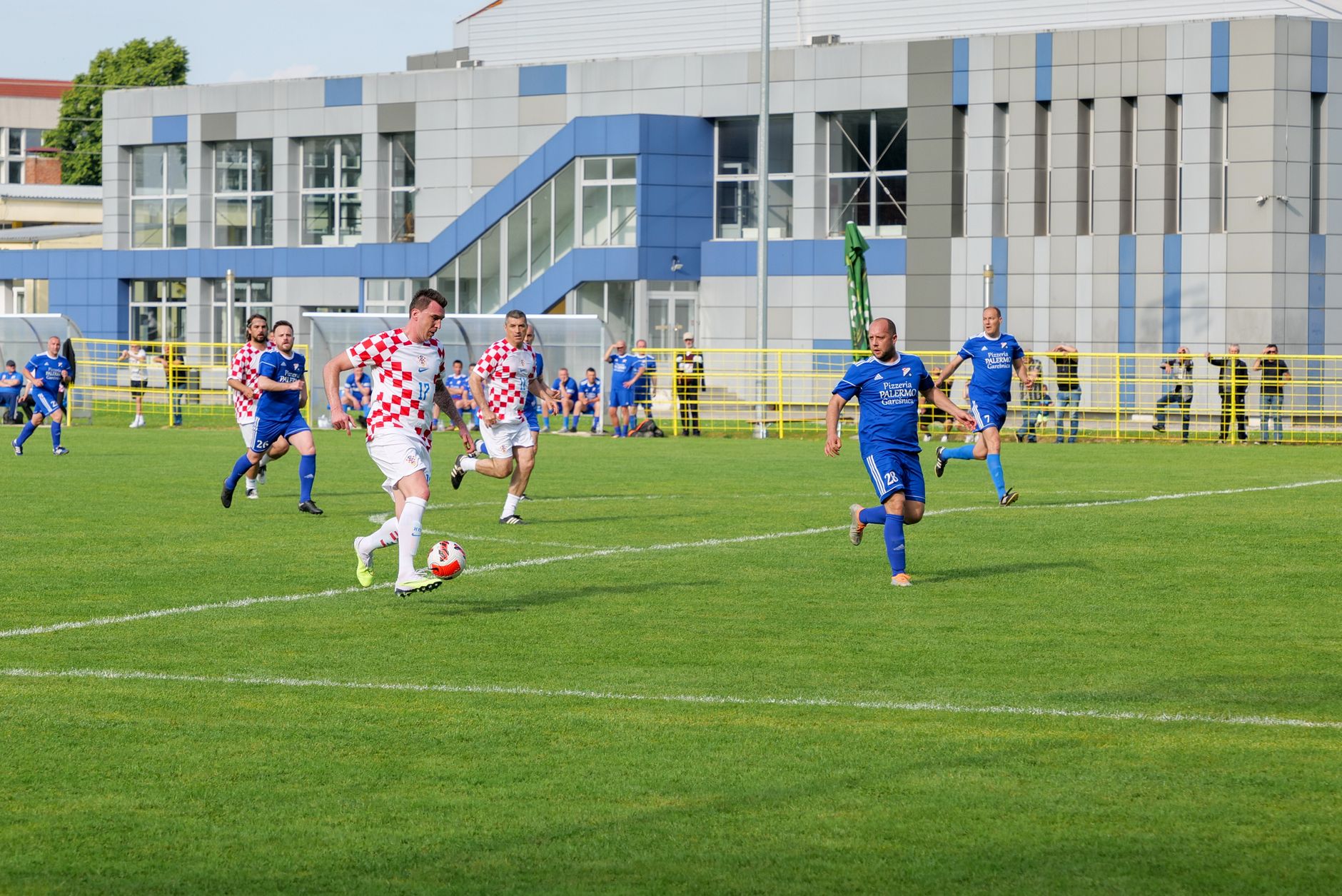 Soccer players in action during a match in Garešnica, Croatia, showcasing competitive sportsmanship.