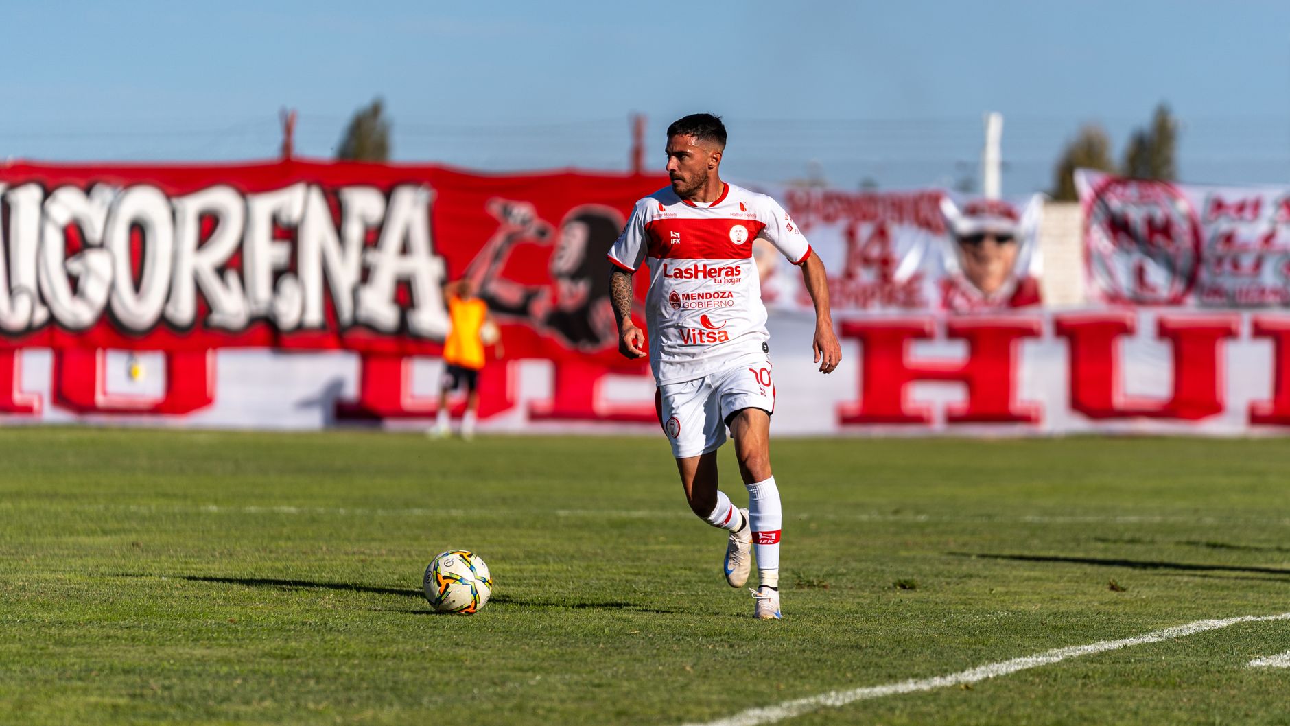 Dynamic shot of a football player on the field during a sunny day match.