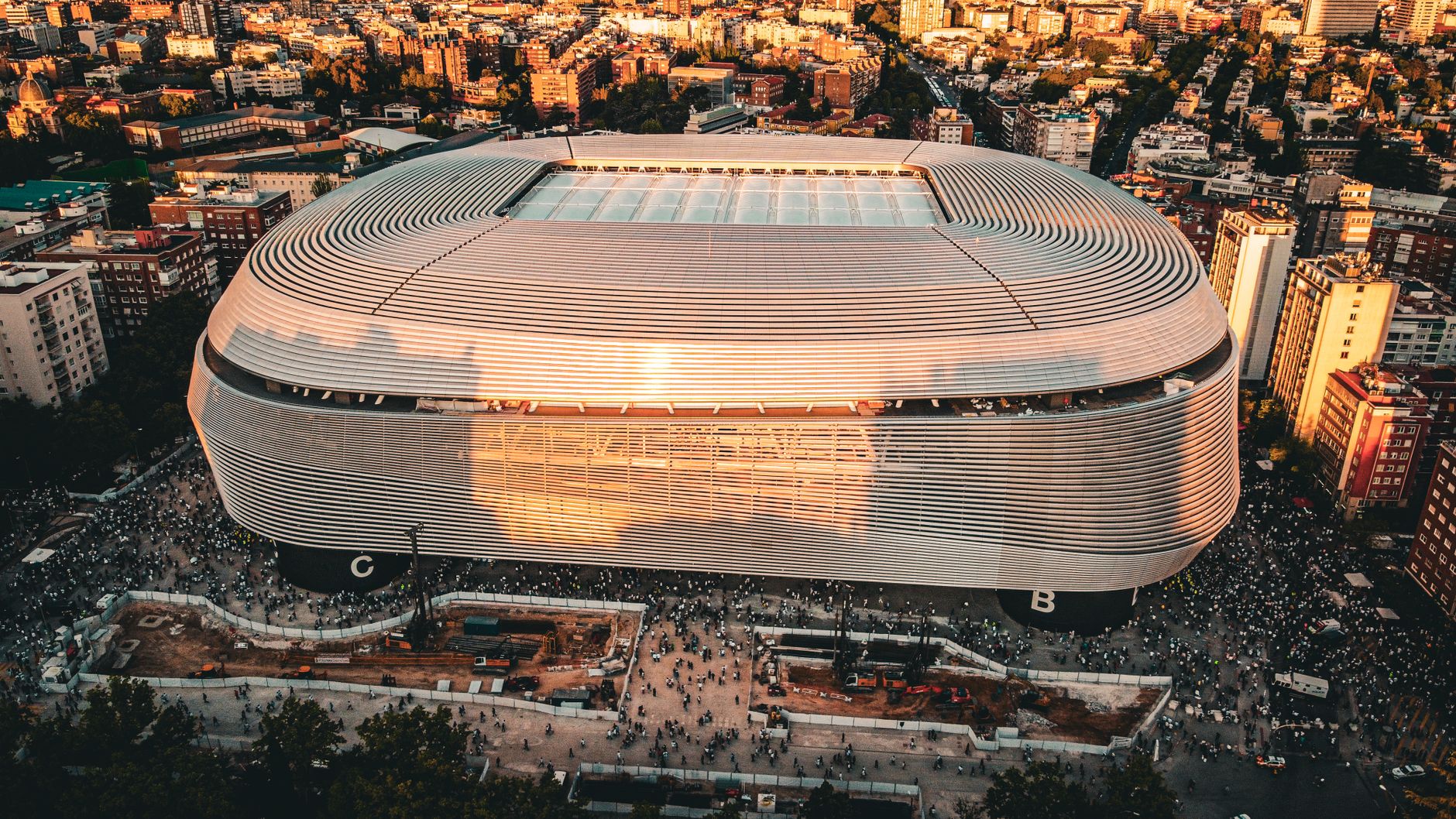 Stunning aerial shot of the Santiago Bernabéu Stadium, Madrid during sunset with bustling cityscape.