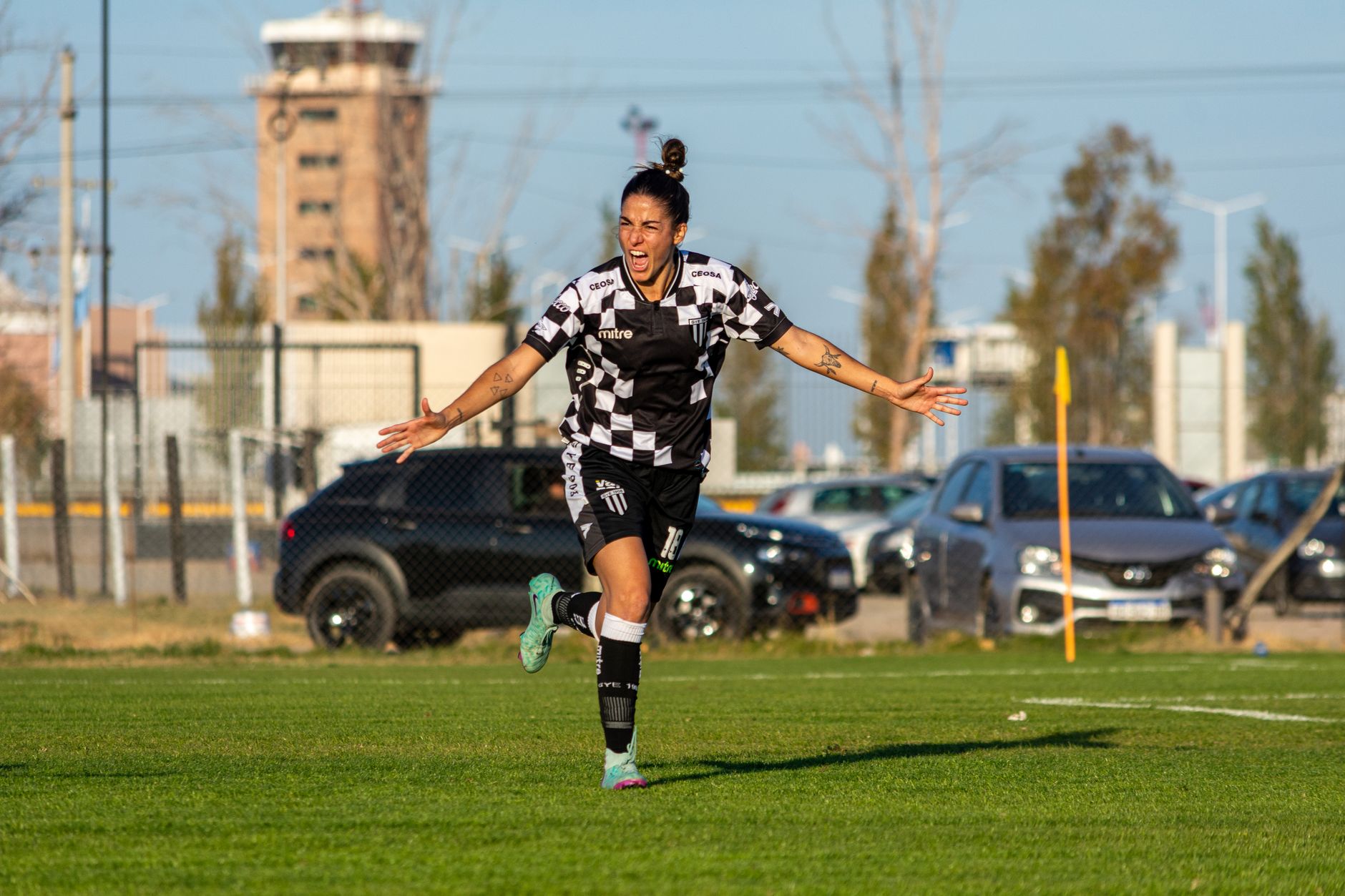 A female footballer celebrates a goal during a match, showcasing her passion and excitement.